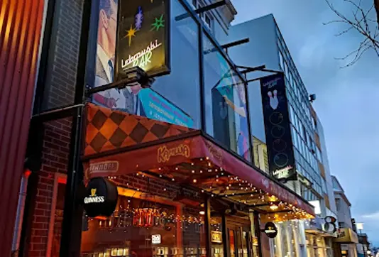 Lebowski Bar in Reykjavík, illuminated with neon lights and cozy decor, offering happy hour deals and a lively nightlife atmosphere.