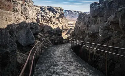A winding wooden walkway through Thingvellir National Park, Iceland.