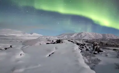 Iceland's Golden Circle during Northern Lights sighting over snow covered ground at Thingvellir.