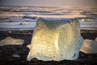Glowing iceberg at sunset on Diamond Beach near Jökulsárlón Glacier Lagoon, Iceland
