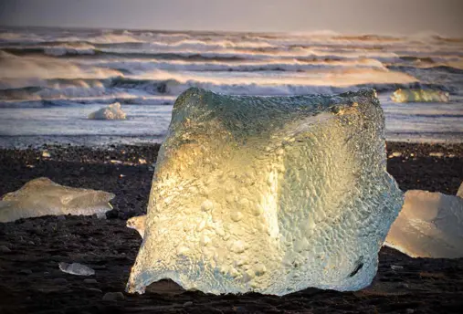 Glowing iceberg at sunset on Diamond Beach near Jökulsárlón Glacier Lagoon, Iceland