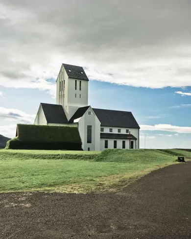 Scenic view of the historic Skalholt Church under cloudy skies, Iceland.