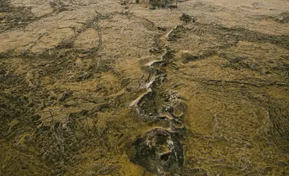 Aerial view of the Eldvörp volcanic crater chain in the Reykjanes Peninsula, Iceland, showcasing the rugged lava fields and volcanic formations stretching into the distance.