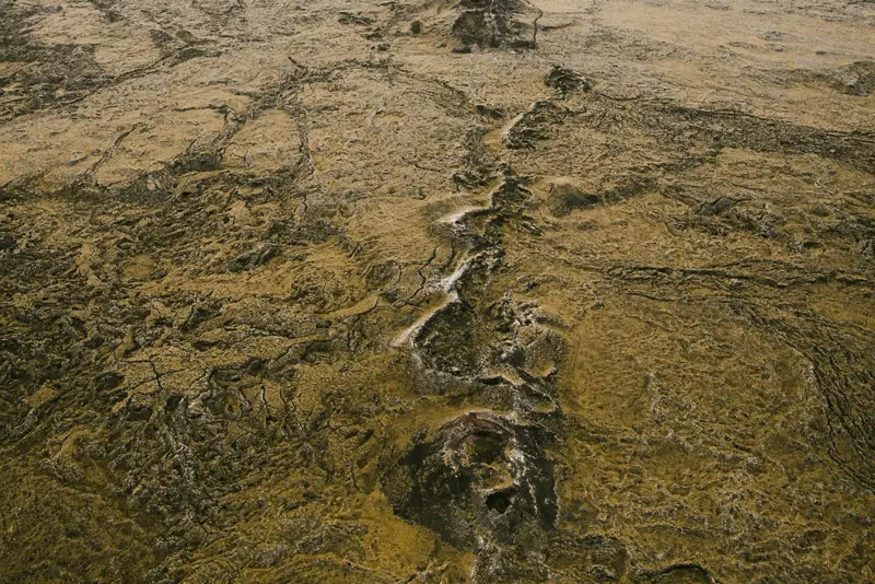 Aerial view of the Eldvörp volcanic crater chain in the Reykjanes Peninsula, Iceland, showcasing the rugged lava fields and volcanic formations stretching into the distance.