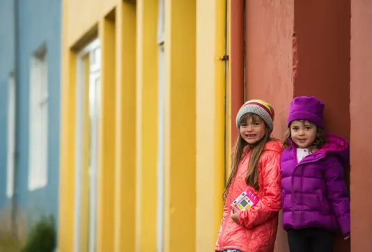 Two Little Girls Next To A Colorful House In Reykjavik Iceland Large