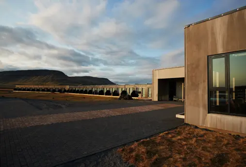 Exterior view of Fosshótel Núpar with mountain views in the back.