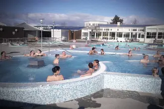 Vesturbaejarlaug swimming pool hot tub area with people relaxing.