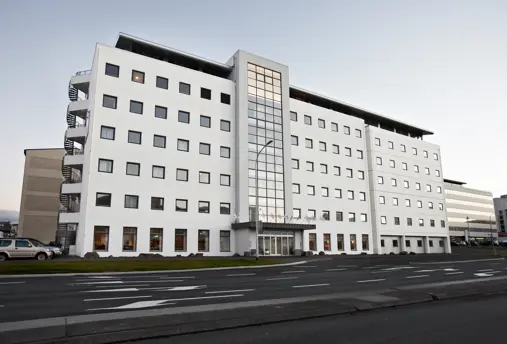 The exterior of Hotel Cabin in Reykjavík, a modern white multi-story building with a glass entrance.