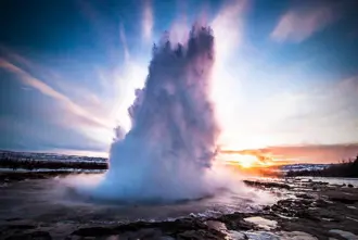 Strokkur geyser erupting in the Geysir geothermal area in Iceland, shooting boiling water high into the air, a key stop on the Golden Circle tour.