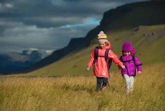 Two Kids In Field With Mountain In Back Iceland Large