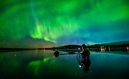 Person in front of a geyser during sunset on a private golden circle tour in Iceland.