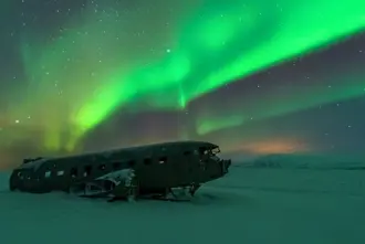 Solheimafjara Black Sand Beach Colorful Northern Lights In Winter Over Airplane Wreck.