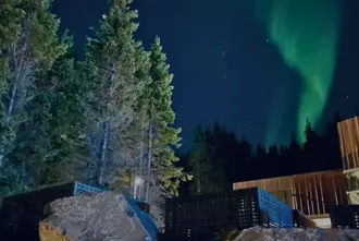 Forest Lagoon Skogarbodin With Green Northern Lights Above The Wooden Facilities Large