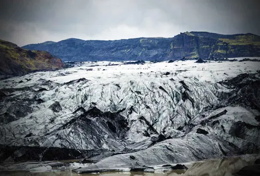 The dramatic landscape of Mýrdalsjökull glacier in Iceland with hikers on the glacier.