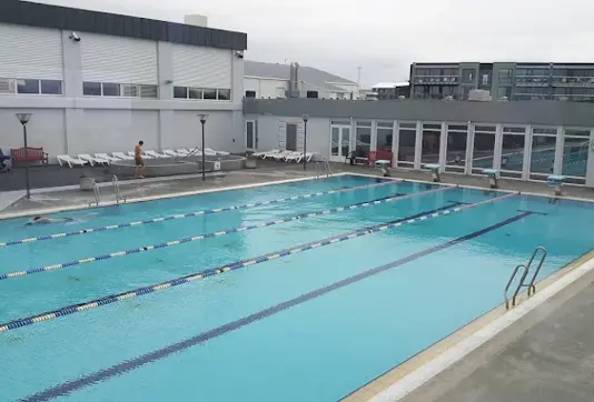 Seltjarnarneslaug outdoor pool in Reykjavik with swimming lanes and lounge chairs under the Icelandic sky.