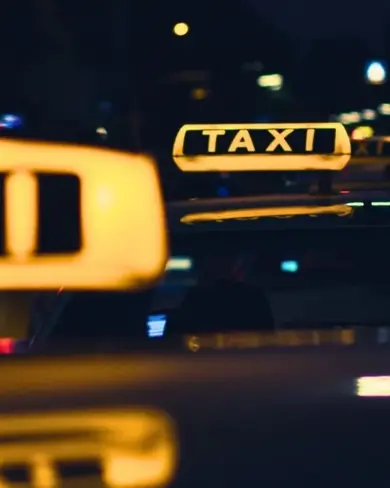 Top of taxis with yellow signs glowing in the dark night. 