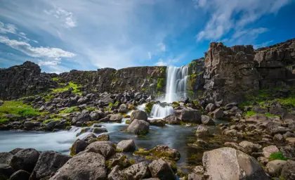 Waterfall cascading through rocky landscape in Thingvellir National Park, seen on stopover day tour with Travel Reykjavik.
