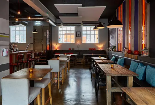 Cozy interior of Forréttabarinn restaurant in Reykjavík, featuring warm lighting, rustic wooden tables, and a welcoming atmosphere perfect for enjoying Icelandic gourmet dishes.