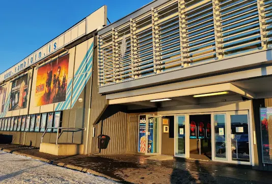 Sambíóin Álfabakka cinema in Reykjavík, Iceland, captured at sunset, highlighting the modern facade and entrance of the movie theater.