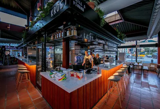 Krost Grill and Wine Bar in Hlemmur Food Hall, Reykjavik, featuring a modern open-bar concept with elegant seating and vibrant evening ambiance.