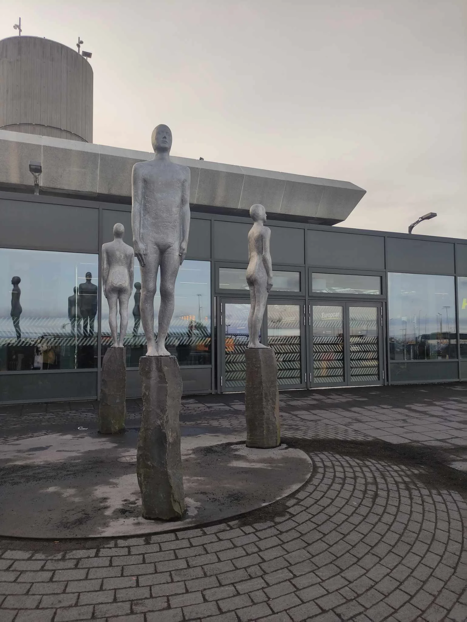 Metal sculpture art of standing humans outside Keflavik Airport in Iceland.