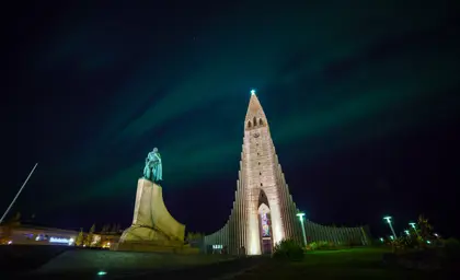 Northern lights illuminating the sky above Hallgrímskirkja church in Reykjavik, Iceland.