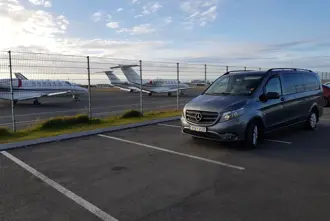 Private tour shuttle at the airport in front of airplanes in Keflavík Iceland.