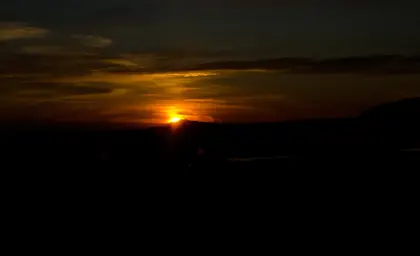 Iceland Sun Casting Golden Colors in the Sky With Pitch Black Landscapes In Darkness.