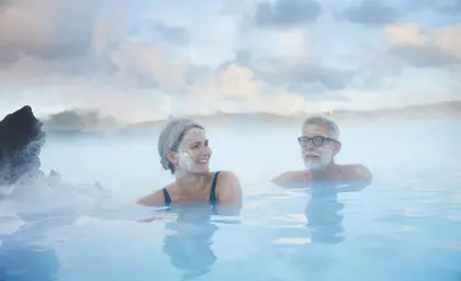 Aerial view of the Blue Lagoon in Iceland during winter, surrounded by snowy lava fields, with geothermal pools and spa facilities nestled in a serene, icy landscape.