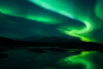 Green Northern Lights in Dark sky in Iceland.