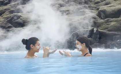Aerial view of the Blue Lagoon in Iceland during winter, surrounded by snowy lava fields, with geothermal pools and spa facilities nestled in a serene, icy landscape.