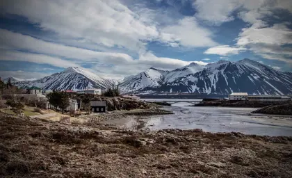 Scenic view of Borgarnes coastal town with snow-capped mountains in the background.