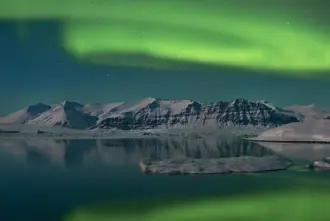 Green Northern Lights View Over Jokulsarlon From Diamond Beach Iceland.
