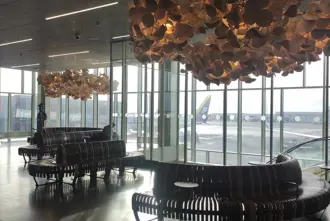 Keflavik airport interior seating area in modern design with calm lighting entering large wall-to-ceiling windows.