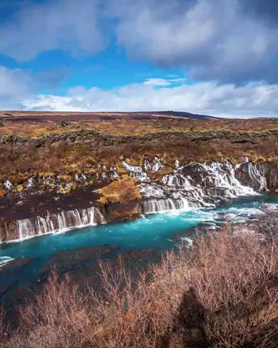 Hraunfossar waterfalls, a stunning series of lava waterfalls in West Iceland, with water cascading from beneath a lava field into the Hvítá river.
