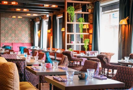 Interior of Fjallkonan Restaurant in Reykjavik featuring cozy, colorful seating and decorative lighting, providing a warm and inviting dining atmosphere