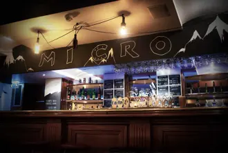 Micro Bar in Reykjavik, a craft beer bar with a minimalist aesthetic, featuring a wide selection of local and international beers displayed on a chalkboard menu.