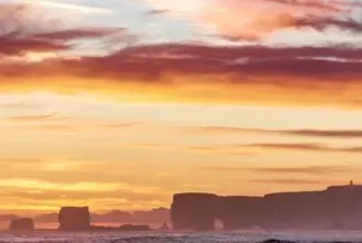Midnight Sun in Iceland over Dyrholaey cliffs at the South shore.