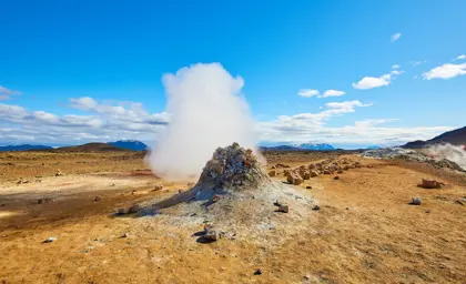 Námaskarð Geothermal Area with steam rising up to a blue clear sky.