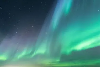 Aurora Borealis in Green color in the night Sky in Iceland.