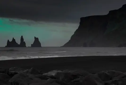 Fade light from northern lights over Vikurfjara beach and Reynisdrangar Iceland.