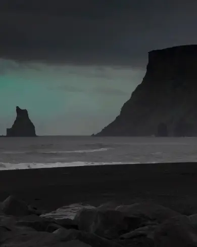 Fade light from northern lights over Vikurfjara beach and Reynisdrangar Iceland.