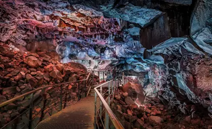Views inside Raufarhólshellir lava tunnel cave in Iceland with walking path going through the cave.