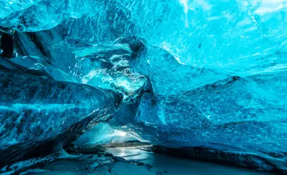 Mesmerizing blue crystal ice cave with an underground river beneath the Icelandic glacier, offering a unique natural wonder explored on a Travel Reykjavik tour.