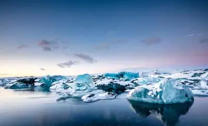 Icebergs floating in the serene waters of Jökulsárlón glacial lagoon in Iceland.