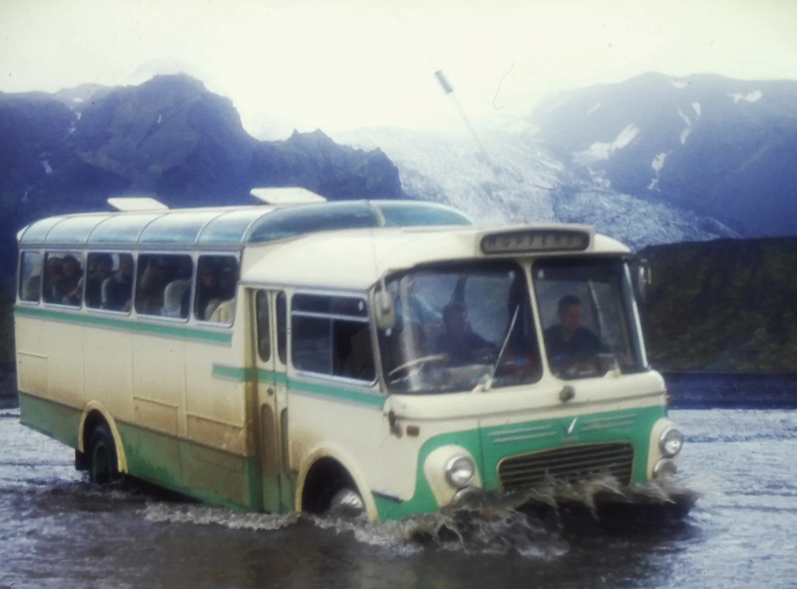Snaeland travel bus drives through a highland river on route to Thorsmork ca. 1970.