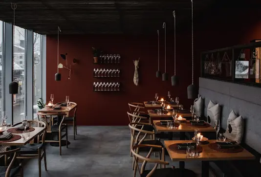 A cozy interior of Dill Restaurant in Reykjavík featuring minimalistic Nordic design, candlelit tables, and a warm ambiance ideal for a fine dining experience focused on local Icelandic flavors.