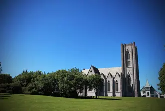 Landakotskirkja, also known as the Cathedral of Christ the King, a Gothic Revival church located in Reykjavík, Iceland, surrounded by greenery.