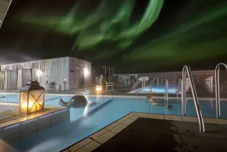 Fontana geothermal pools Laugarvatn with the Northern Lights glowing above in Iceland.