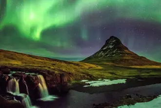 Kirkjufell at Snaefellsnes with Northern Lights above the mountain and waterfall.